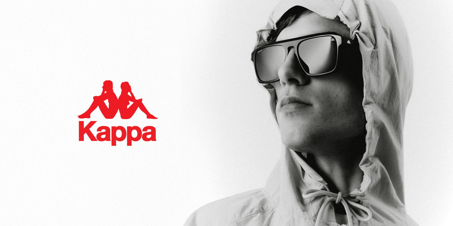 A person in a light hooded jacket and large dark sunglasses looks off to the side. The red Kappa logo, featuring two seated back-to-back figures and the word Kappa, appears prominently on the left.