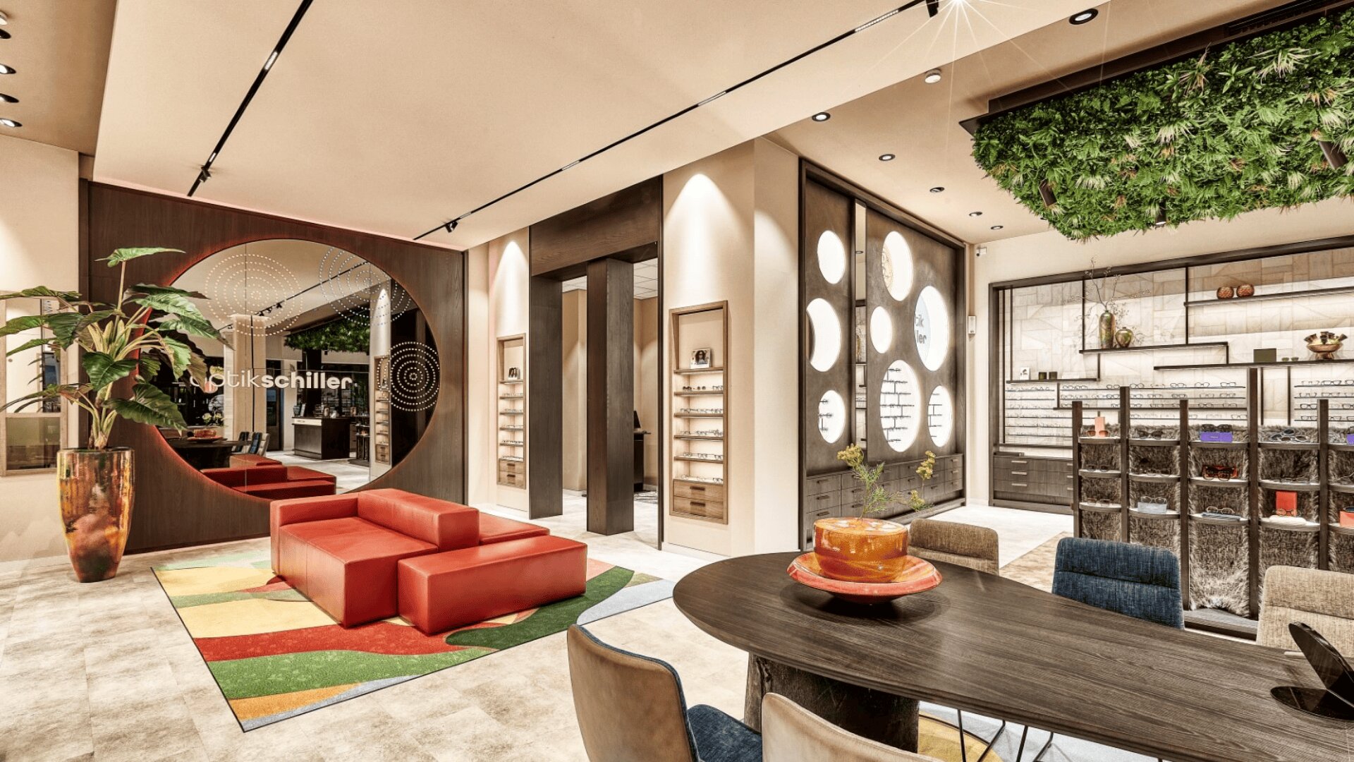 A modern eyewear store with stylish red seating, large round mirrors, display shelves with glasses, a black table with chairs, and a green plant feature on the ceiling. The space is bright and contemporary.