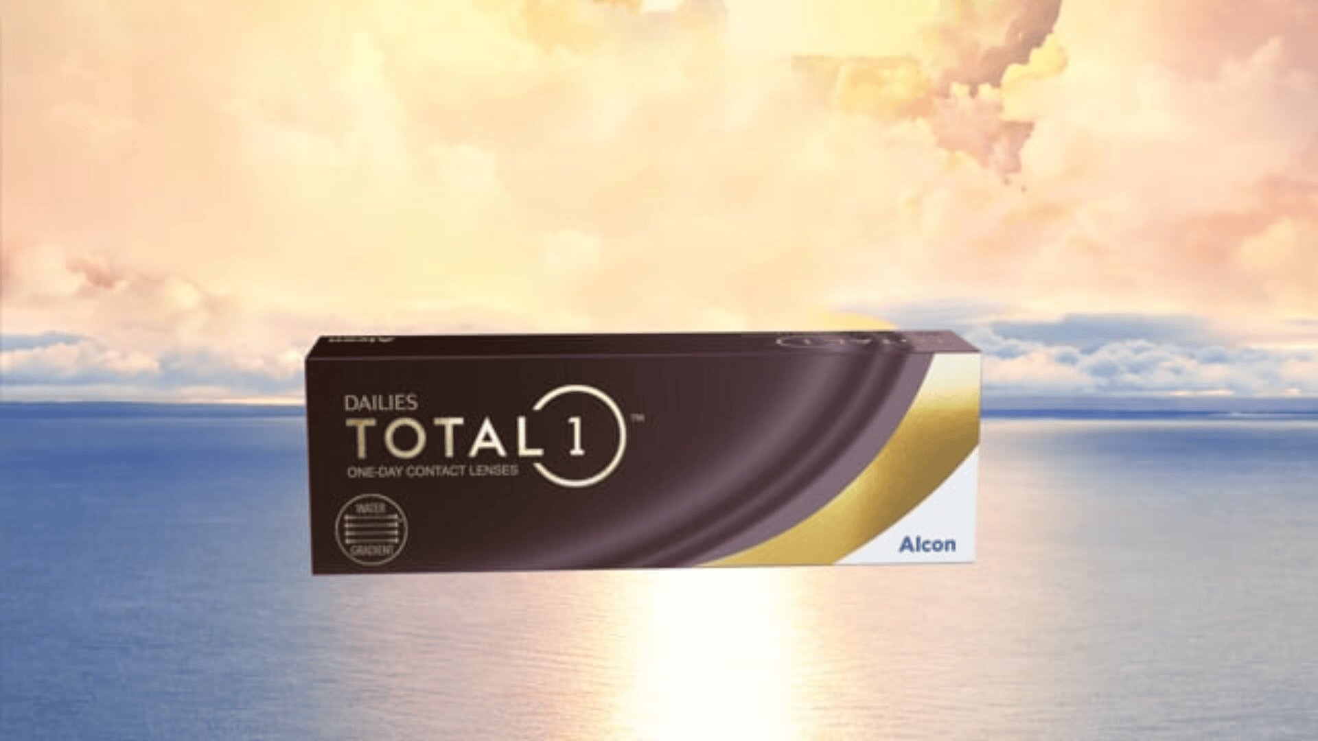 A box of Dailies Total 1 one-day contact lenses by Alcon is shown against a serene background of a glowing sky and calm water at sunrise or sunset.