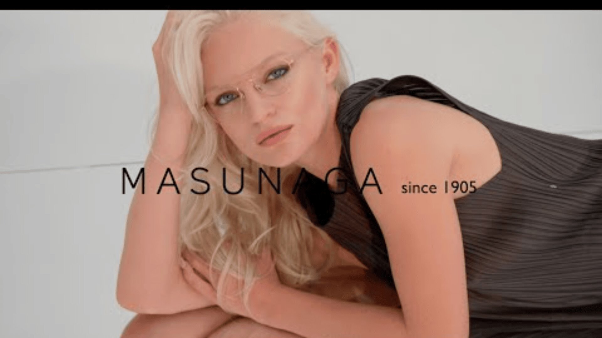 A woman with platinum blonde hair, glasses, and a sleeveless black top poses leaning on one arm. The text MASUNAGA since 1905 is visible above the image.