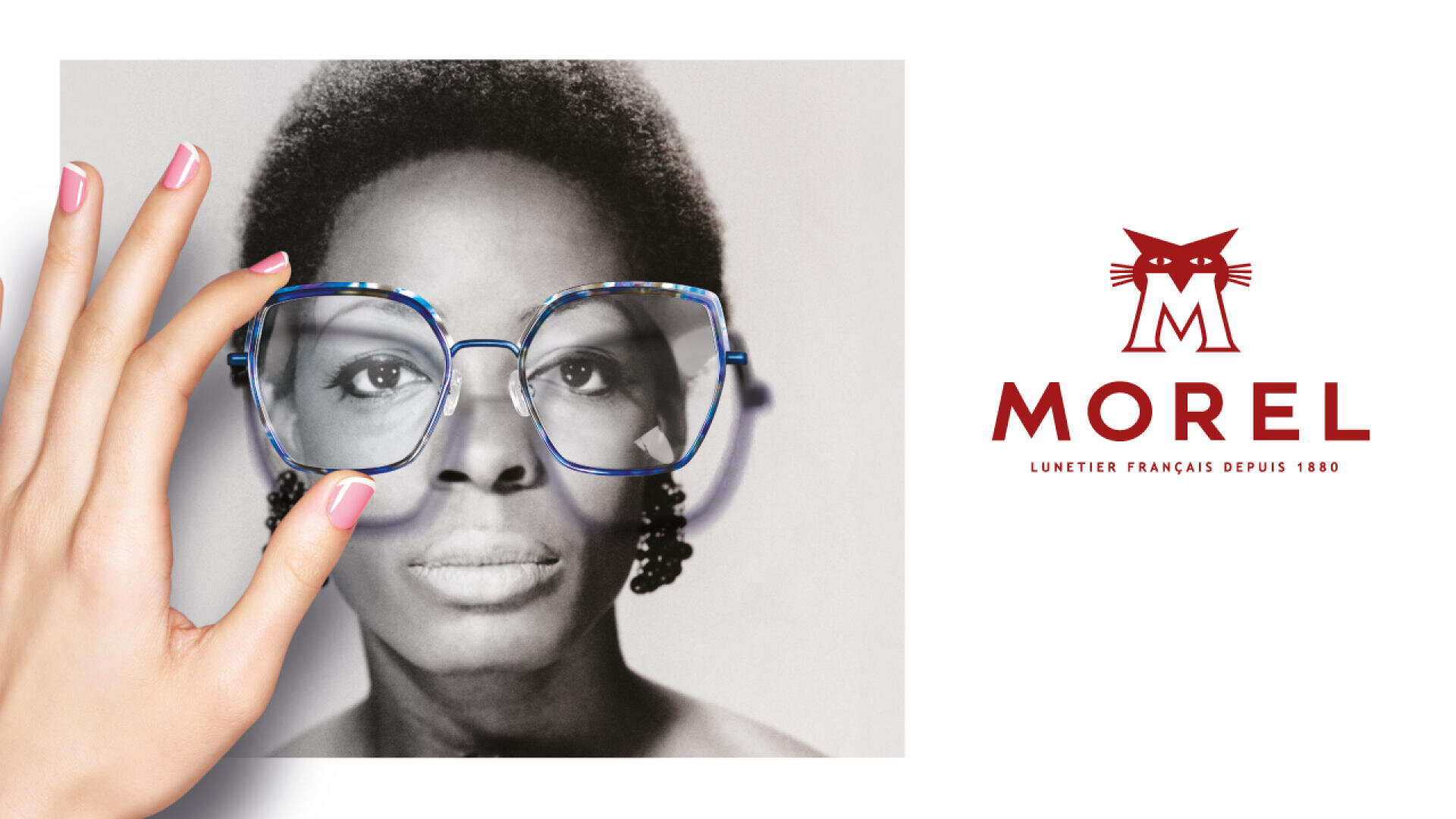 Eine Hand mit rosa Nagellack hält ein Schwarz-Weiß-Foto des Gesichts einer Frau und setzt eine übergroße blaue Brille auf. Rechts daneben sind ein rotes Katzenlogo und das Wort MOREL in französischer Schrift auf weißem Hintergrund zu sehen.