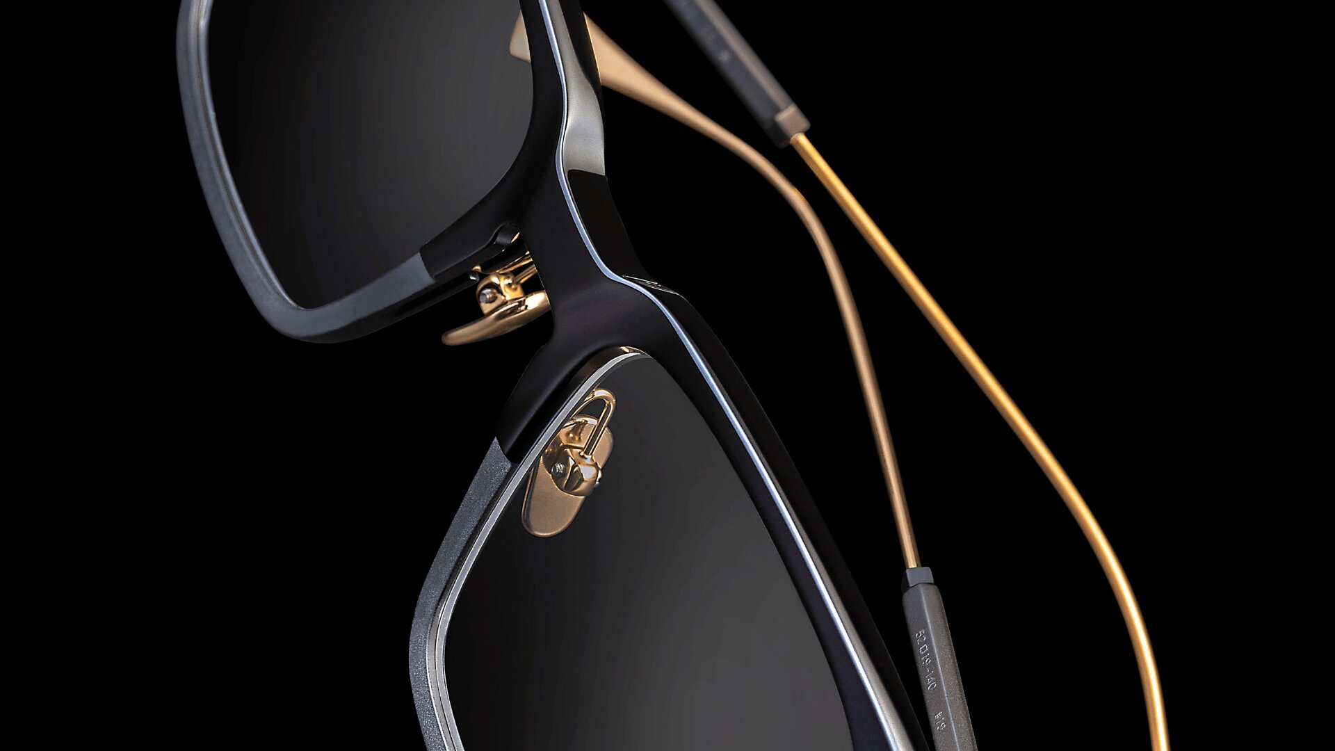 Nahaufnahme einer stilvollen schwarzen Sonnenbrille mit goldenen Nasenpads und dünnen goldenen Bügeln vor einem schwarzen Hintergrund. Das Bild hebt die luxuriösen und modernen Designdetails der Brille hervor.