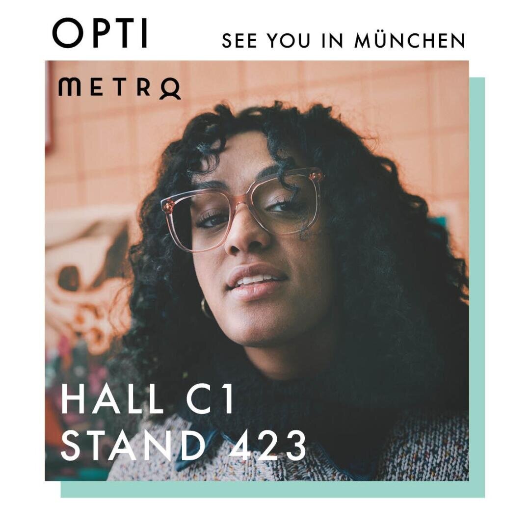 A woman with curly hair and large glasses looks at the camera. Text reads: OPTI METRO, SEE YOU IN MÜNCHEN, HALL C1 STAND 423. The design promotes an event or exhibition in Munich.