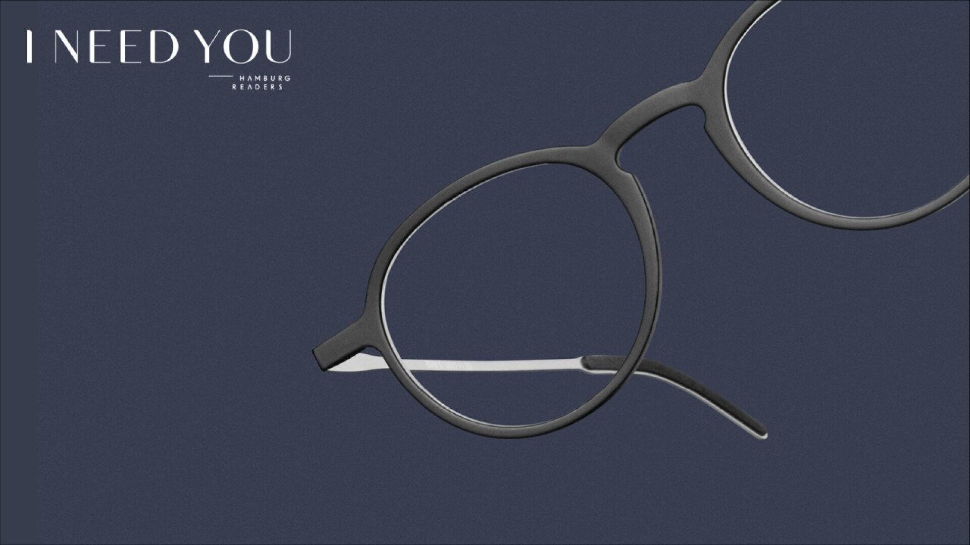 A minimalist image features round black eyeglass frames on a dark blue background, with the text I NEED YOU Hamburg Readers in the top left corner.