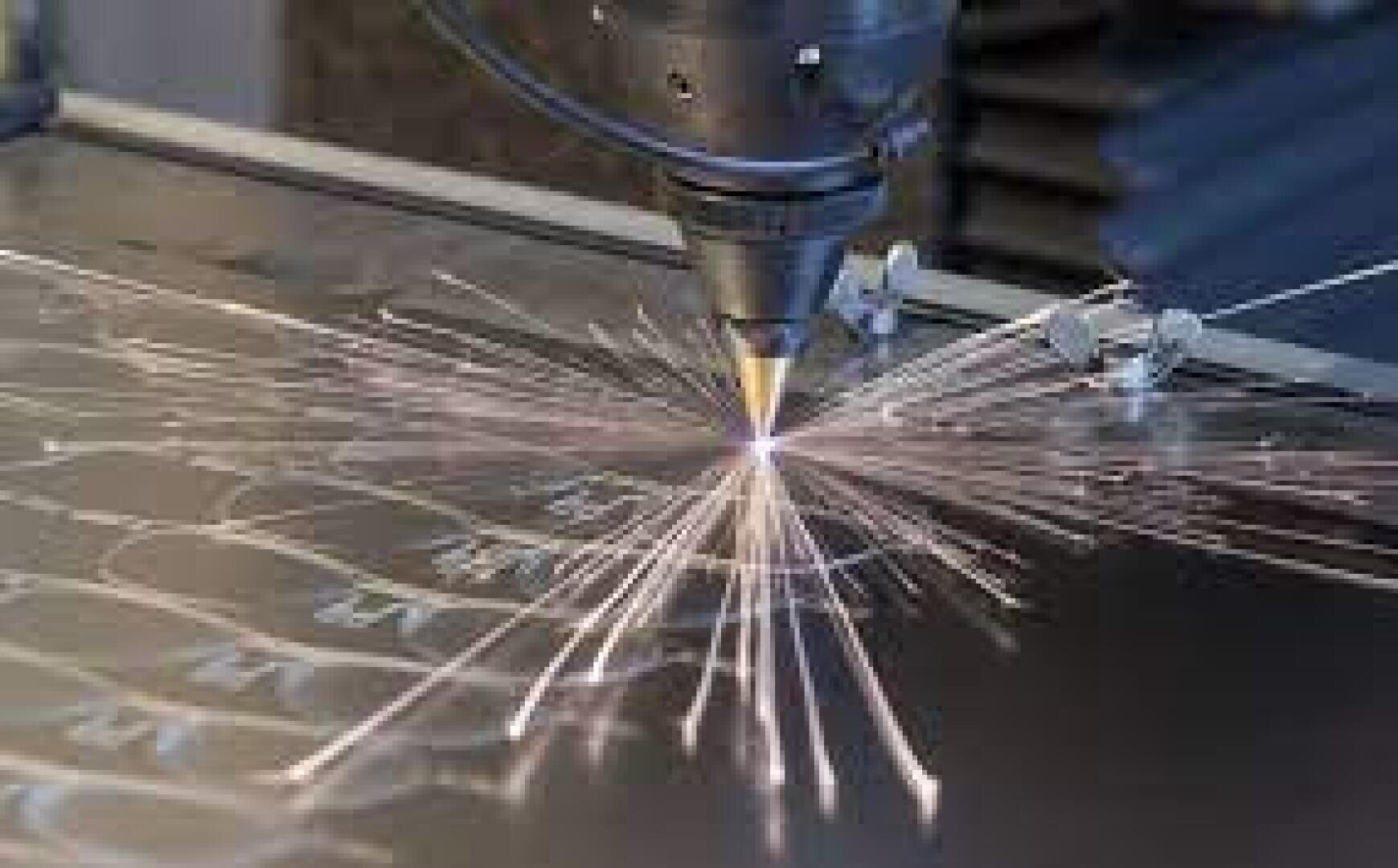 Eine Nahaufnahme einer Laserschneidmaschine, die helle Funken sprüht, während sie komplizierte Muster in ein Metallblech schneidet.