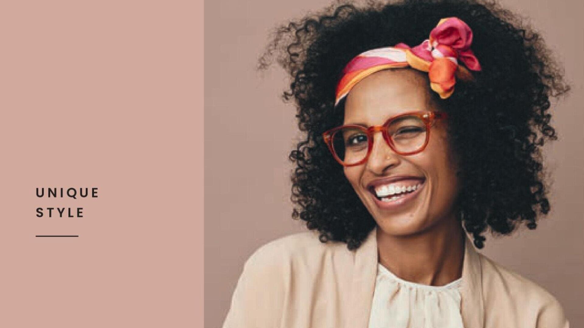 Smiling person with curly hair, wearing red glasses and a colorful headband with a bow, stands against a neutral background. The left side of the image features the text “UNIQUE STYLE” on a pinkish panel.