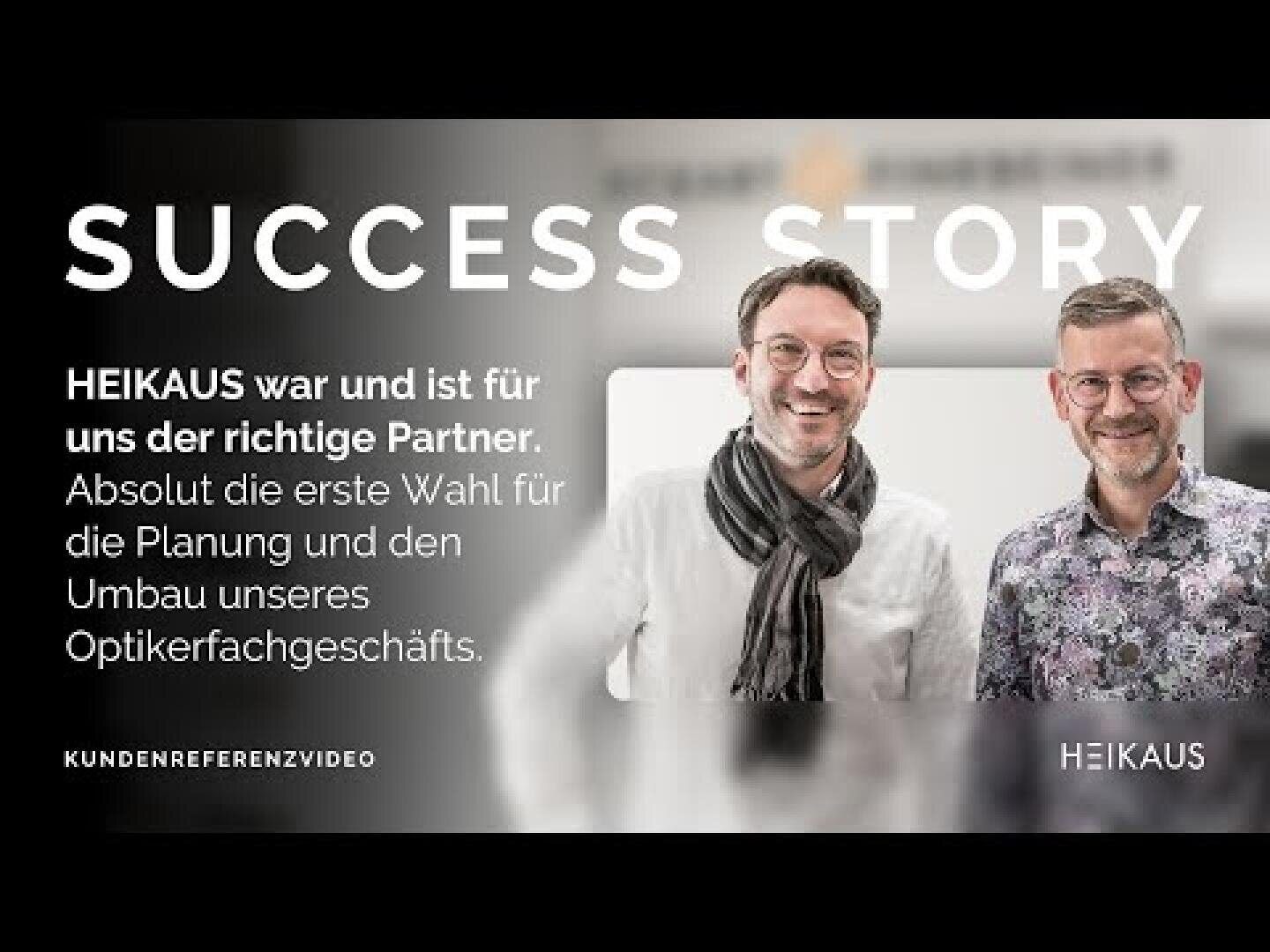 Zwei lächelnde Männer stehen Seite an Seite vor einem unscharfen Hintergrund. Der Text neben ihnen lautet: ERFOLGSGESCHICHTE. HEIKAUS war und ist für uns der richtige Partner... Förderung einer positiven Geschäftspartnerschaft mit HEIKAUS.
