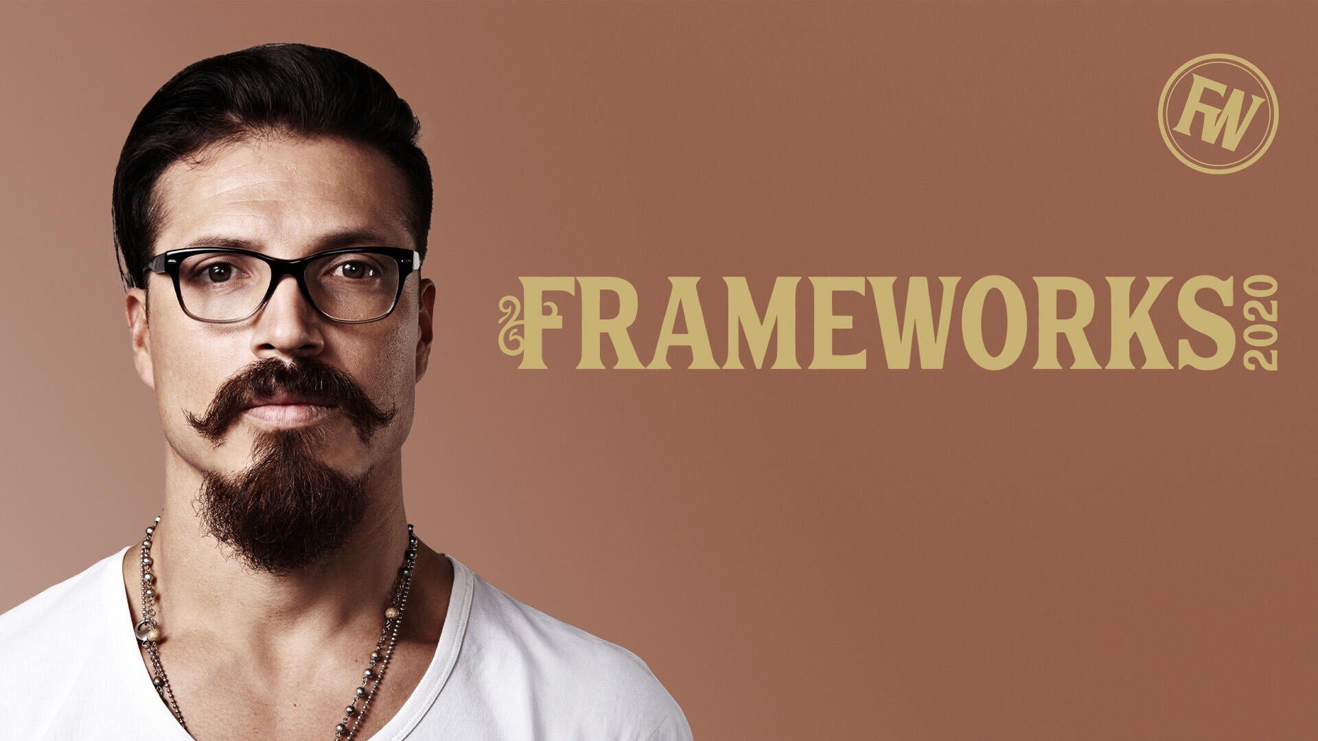 Ein Mann mit dunklem Haar, Brille, gestyltem Schnurrbart und Bart steht vor einem braunen Hintergrund. Neben ihm erscheinen in großen, goldenen Buchstaben das Wort FRAMEWORKS 2020 und ein rundes FW-Logo.