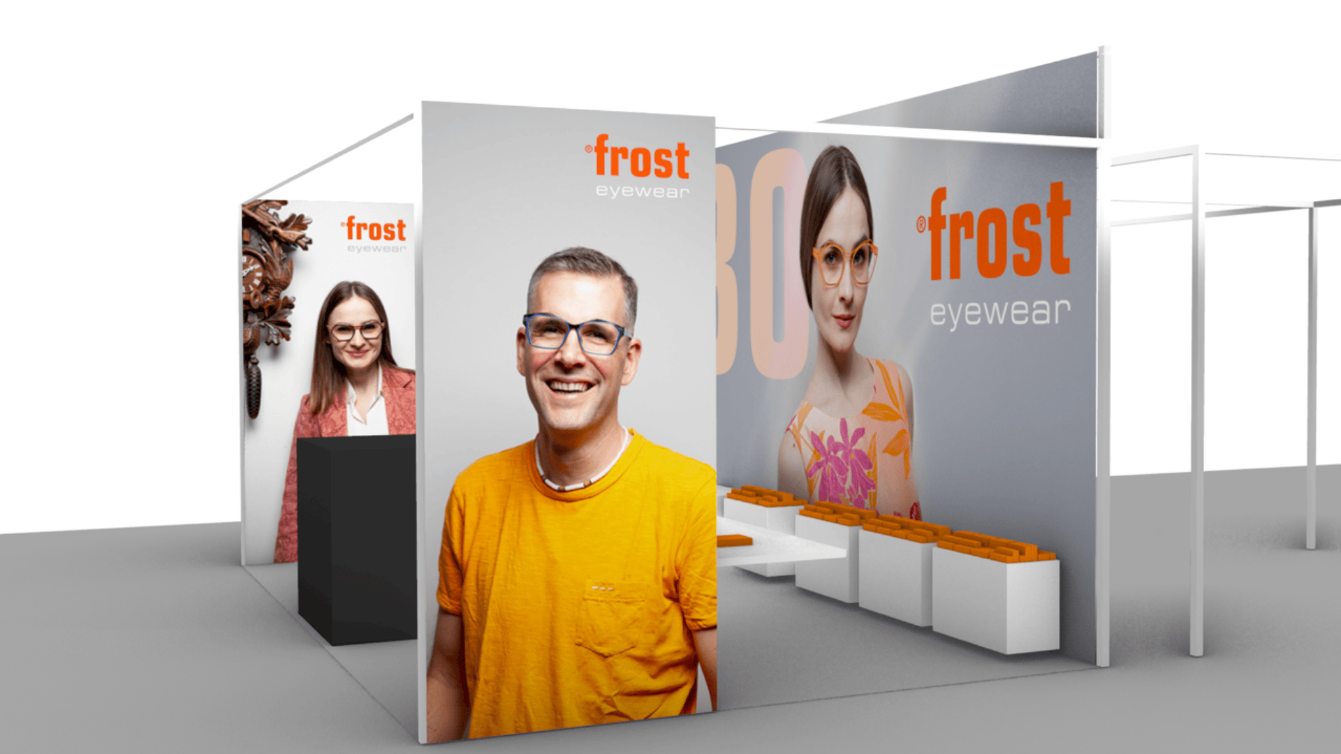 Ein moderner Messestand für Frost Eyewear zeigt große Bilder von lächelnden Brillenmodellen, Markenschilder und einen weißen Sitzbereich mit orangefarbenen Akzenten.