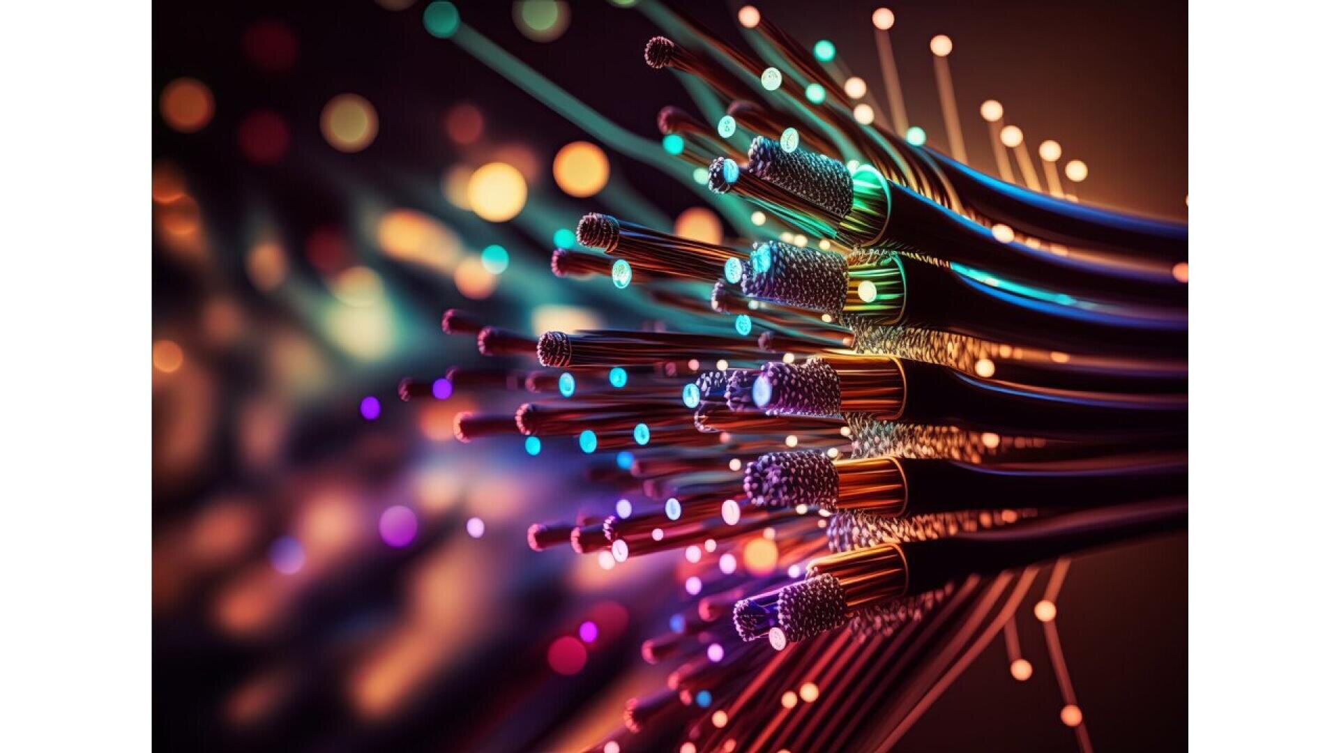 Close-up of colorful fiber optic cables with glowing lights at the ends, set against a blurred dark background. The image highlights the vibrant strands and bright, multicolored points of light.