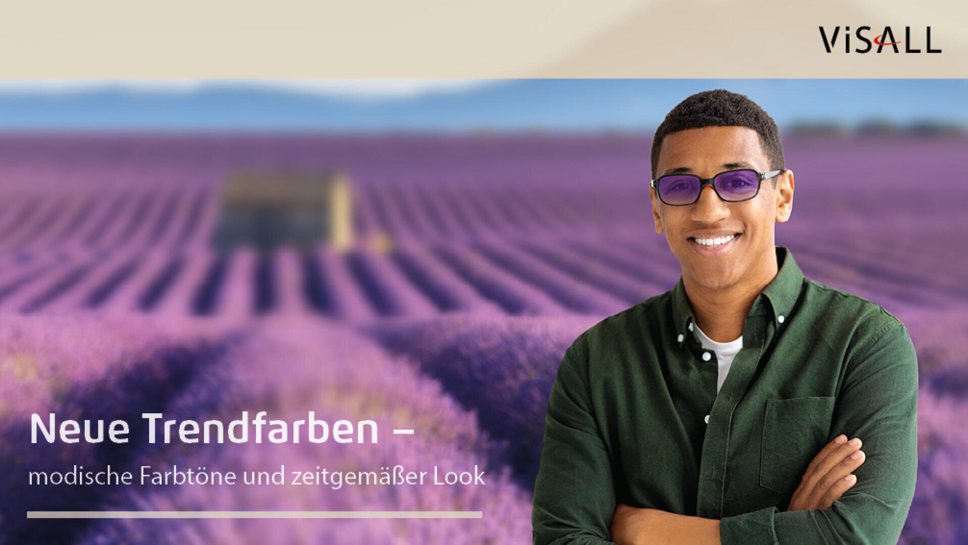 Ein lächelnder Mann mit Sonnenbrille und grünem Hemd steht vor einem verschwommenen Lavendelfeld. Text lautet: Neue Trendfarben – modische Präzision und zeitgemäßer Look. Das ViSALL-Logo befindet sich in der oberen rechten Ecke.