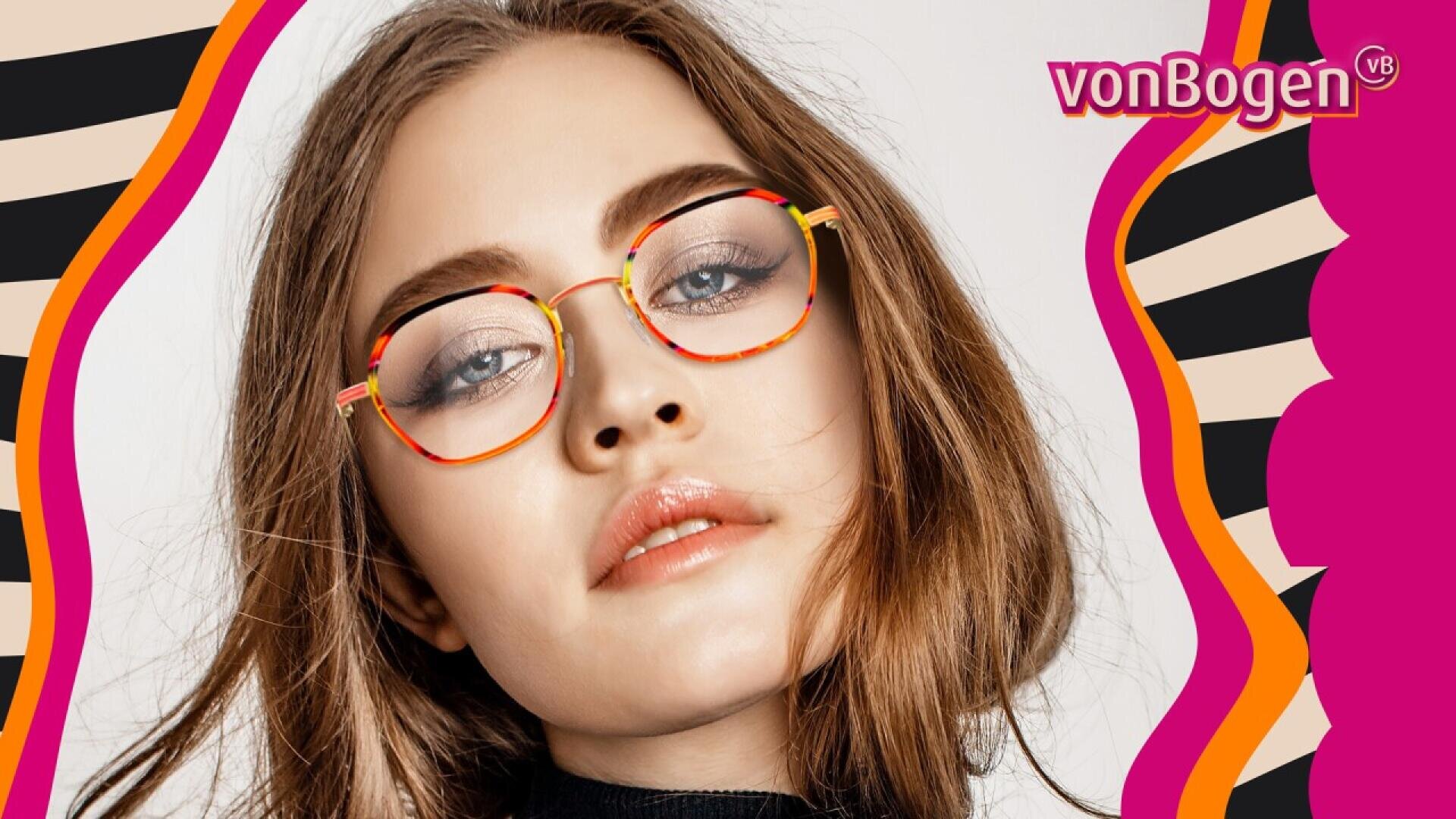 A woman with light brown hair and bold eyebrows wears stylish round glasses with red and yellow frames. The background features wavy pink, orange, and black stripes with the vonBogen logo in the top right corner.