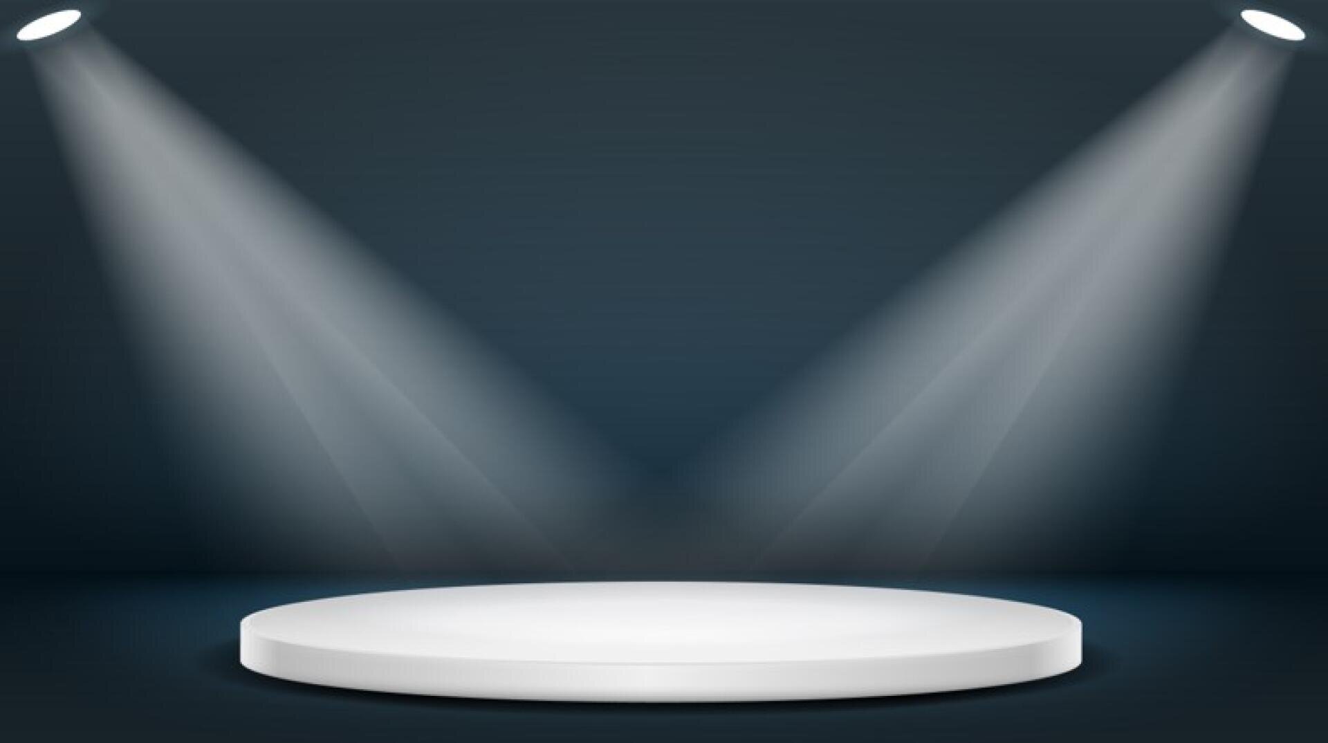 Eine weiße, runde Bühnenplattform wird von zwei sich kreuzenden Scheinwerfern vor einem dunklen Hintergrund beleuchtet, wodurch eine dramatische und fokussierte Kulisse entsteht.