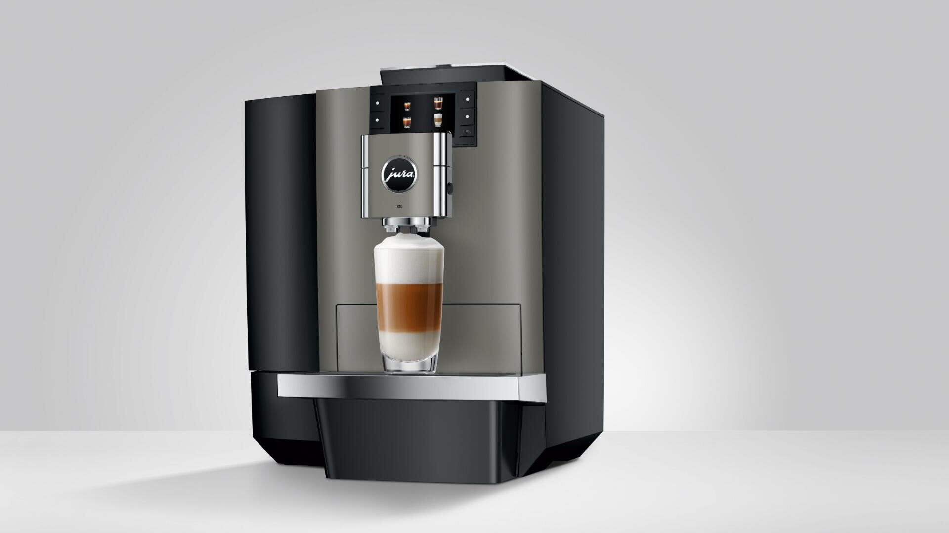 Vor einem schlichten grauen Hintergrund gibt ein eleganter, moderner Kaffeevollautomat einen geschichteten Latte Macchiato in ein Glas aus.