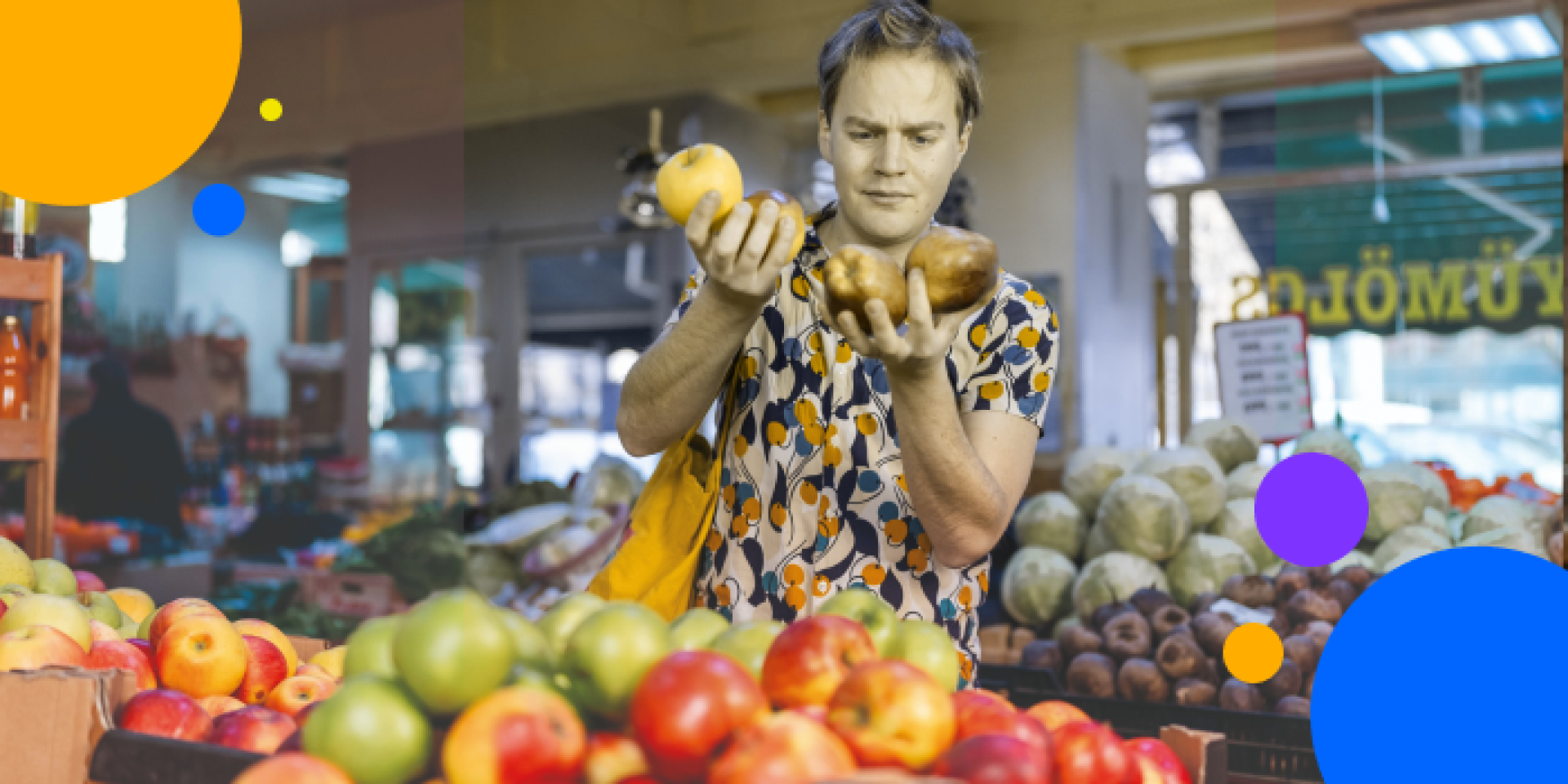 A person at a market stall examines two pieces of fruit, surrounded by apples and other produce. Bright colorful circles are overlaid on the image for a playful effect.