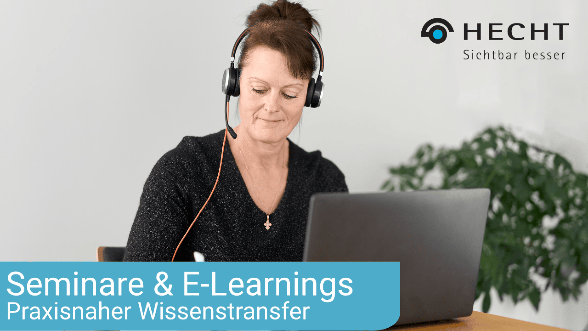 Eine Frau mit Headset sitzt an einem Tisch und nutzt einen Laptop. Der Text auf dem Bild lautet: HECHT Sichtbar besser. Seminare & E-Learnings. Praxisnaher Wissenstransfer.
