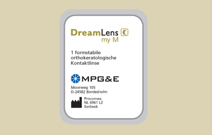 Ein rechteckiges Verpackungsetikett für Kontaktlinsen mit dem Text DreamLens my M, Firmenlogos und Adressen in Deutschland und den Niederlanden auf einem hellbeigen Hintergrund.